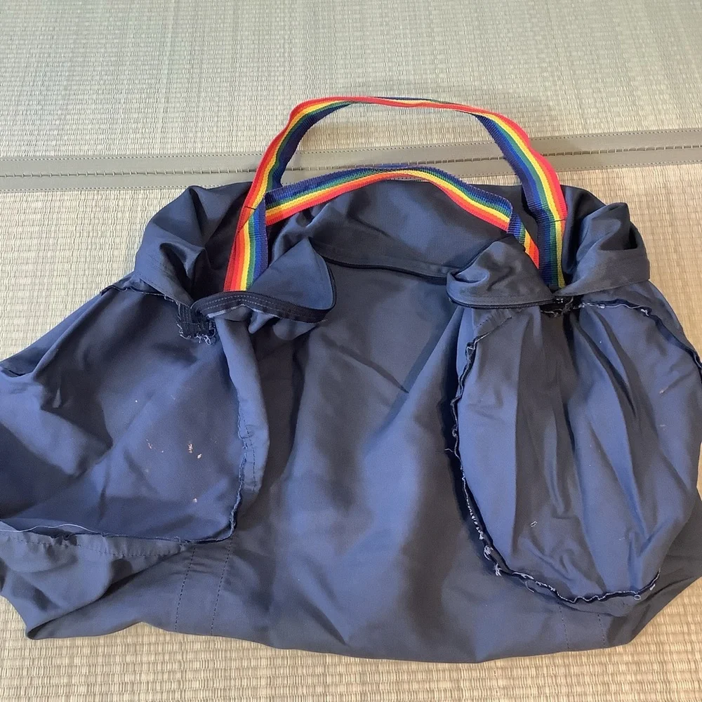 Big blue duffel bag with rainbow stripes handle straps Pride Duffle